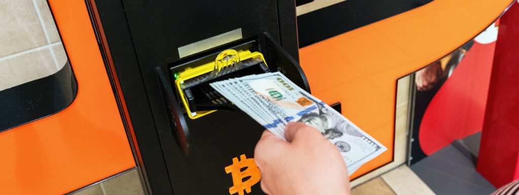 Woman deposits cash into Bitcoin ATM